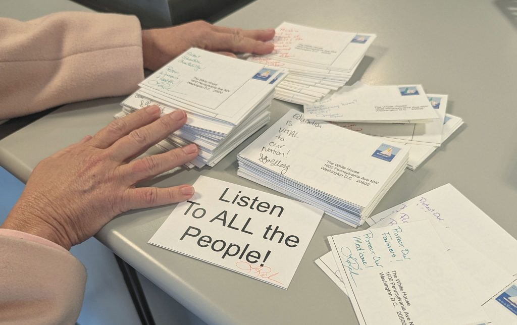 Local residents took part in a national postcard writing campaign designed to express frustration with the Trump administration's actions.
